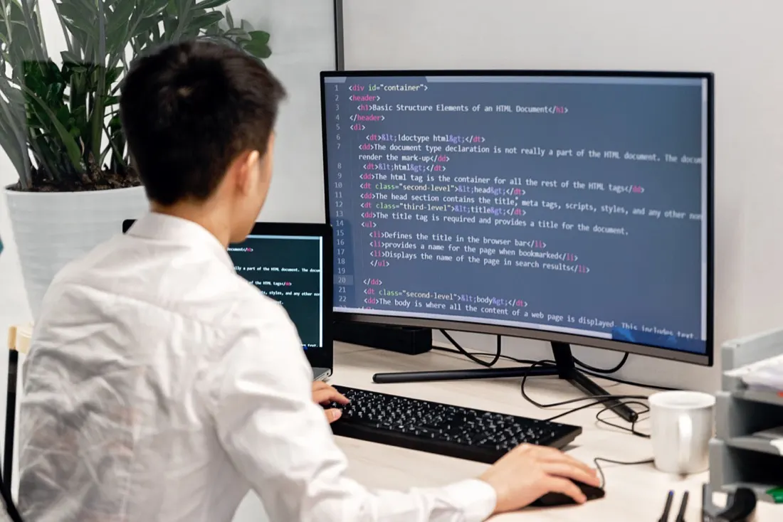 Software engineer building custom applications on dual monitors