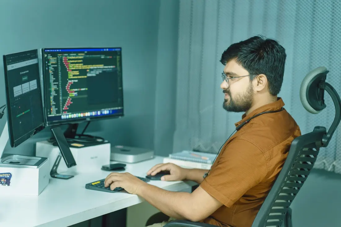 Developer coding websites on dual monitors in a modern office