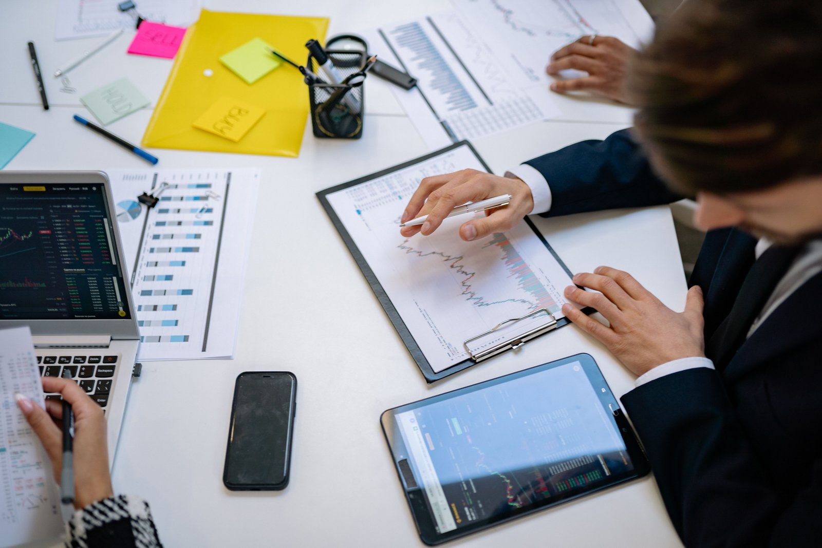 Marketing team reviewing campaign performance charts on tablets