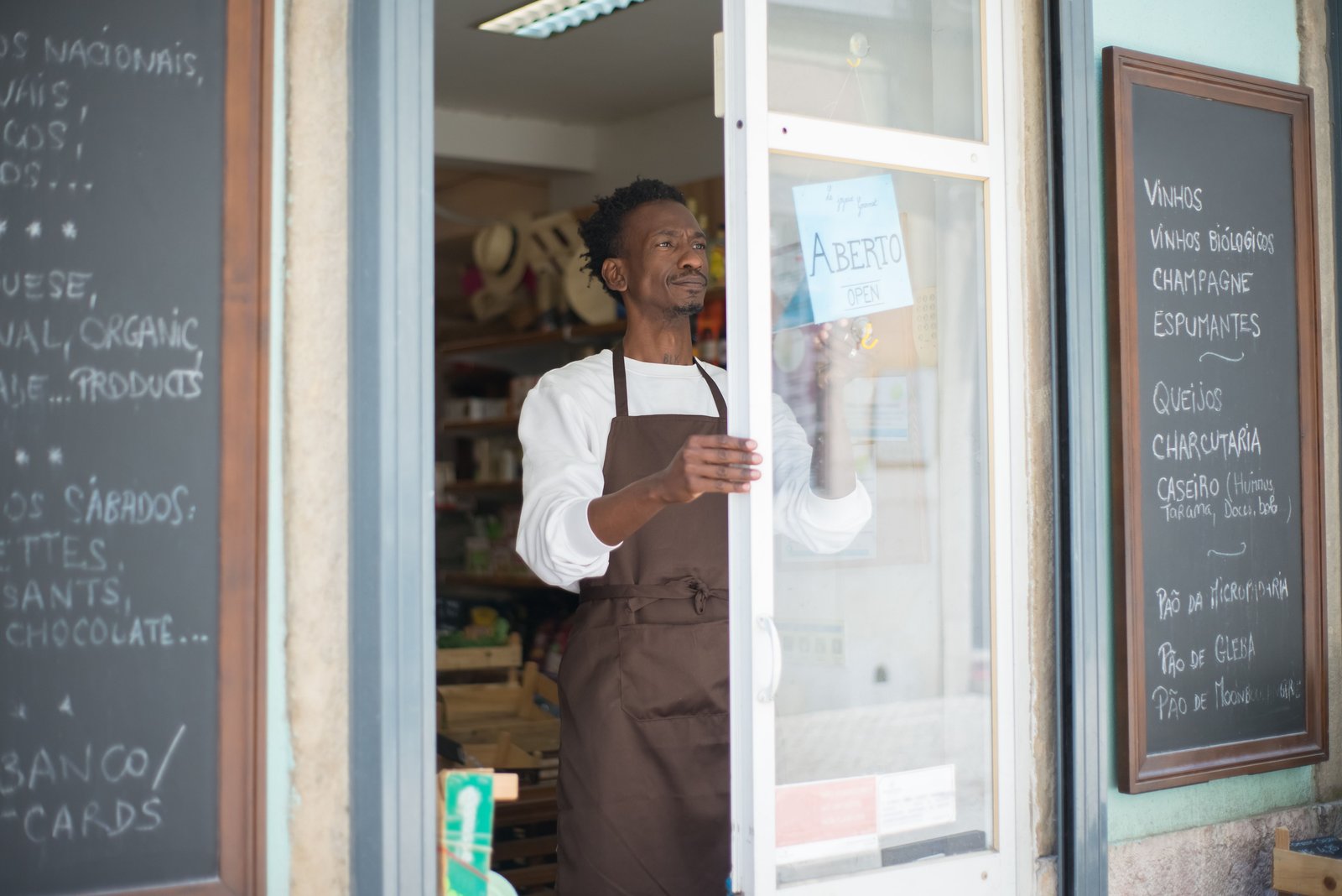 Local business owner opening the storefront to welcome customers