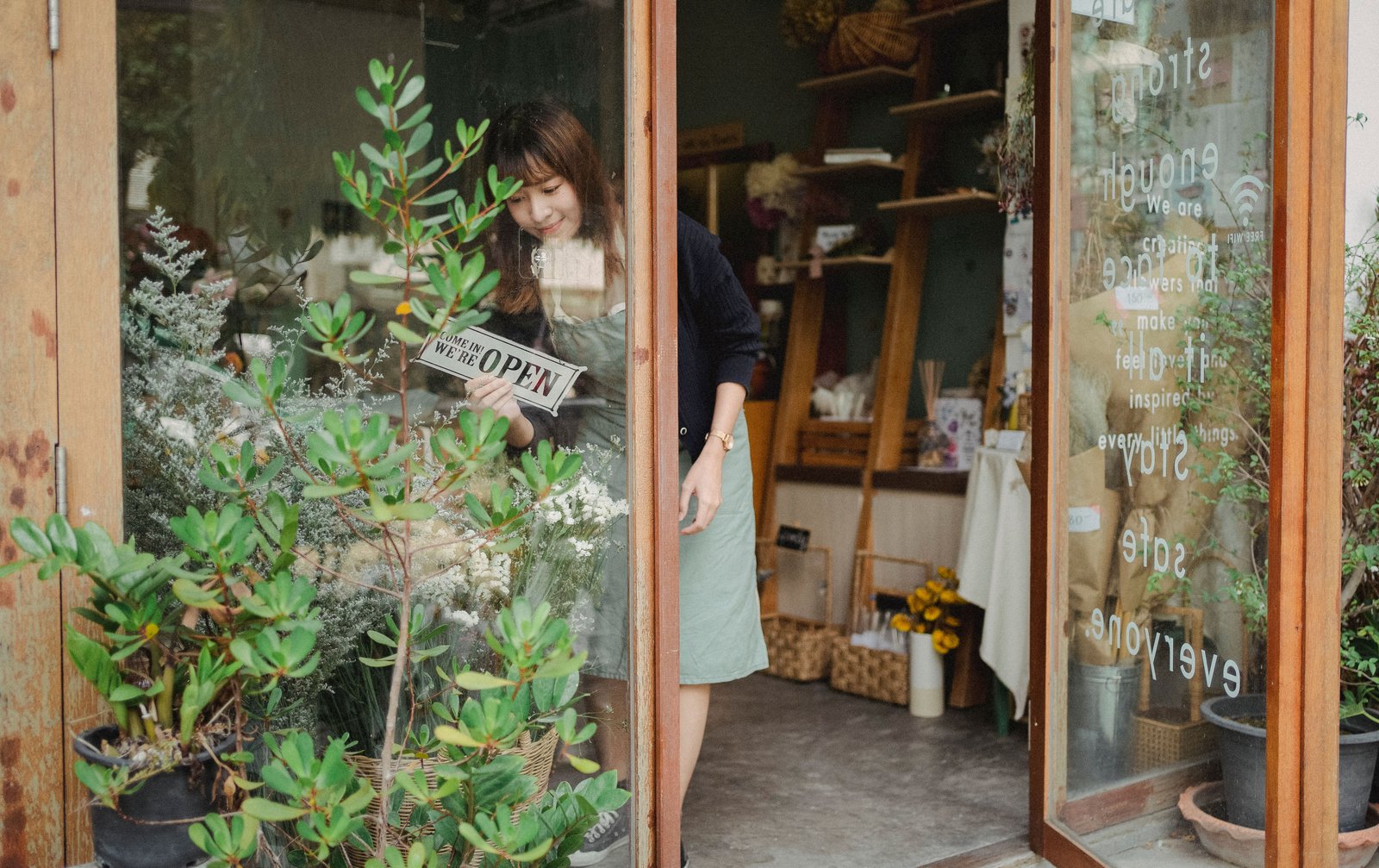 Shop owner placing an open sign in a storefront window
