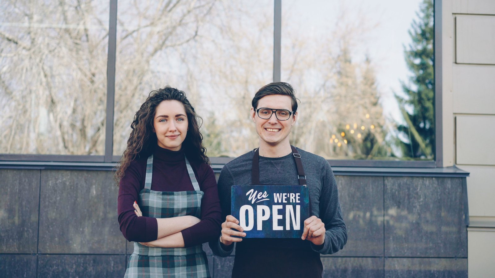 Local business owners displaying an open sign outside their storefront