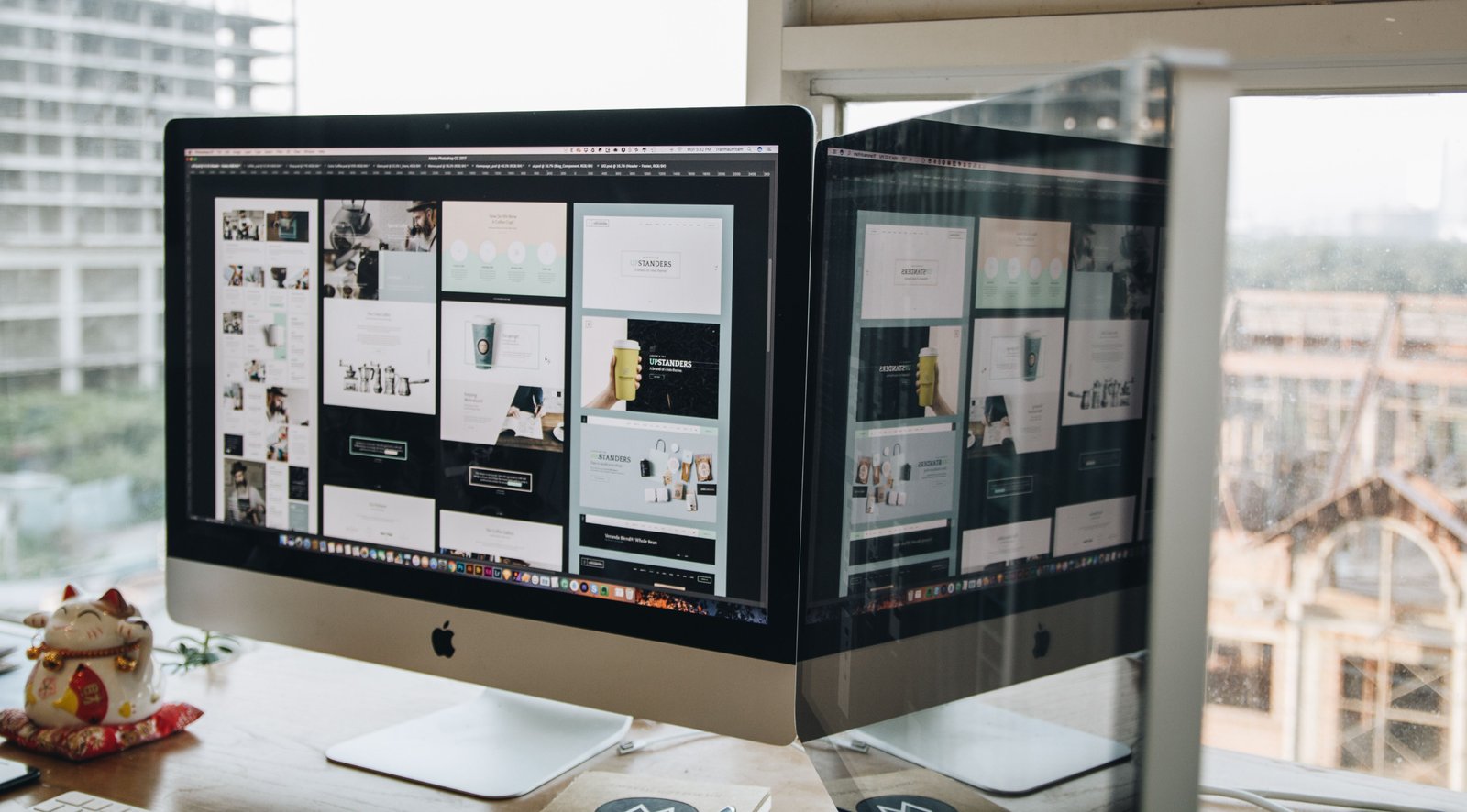 Dual monitors showing web and campaign work in a clean office