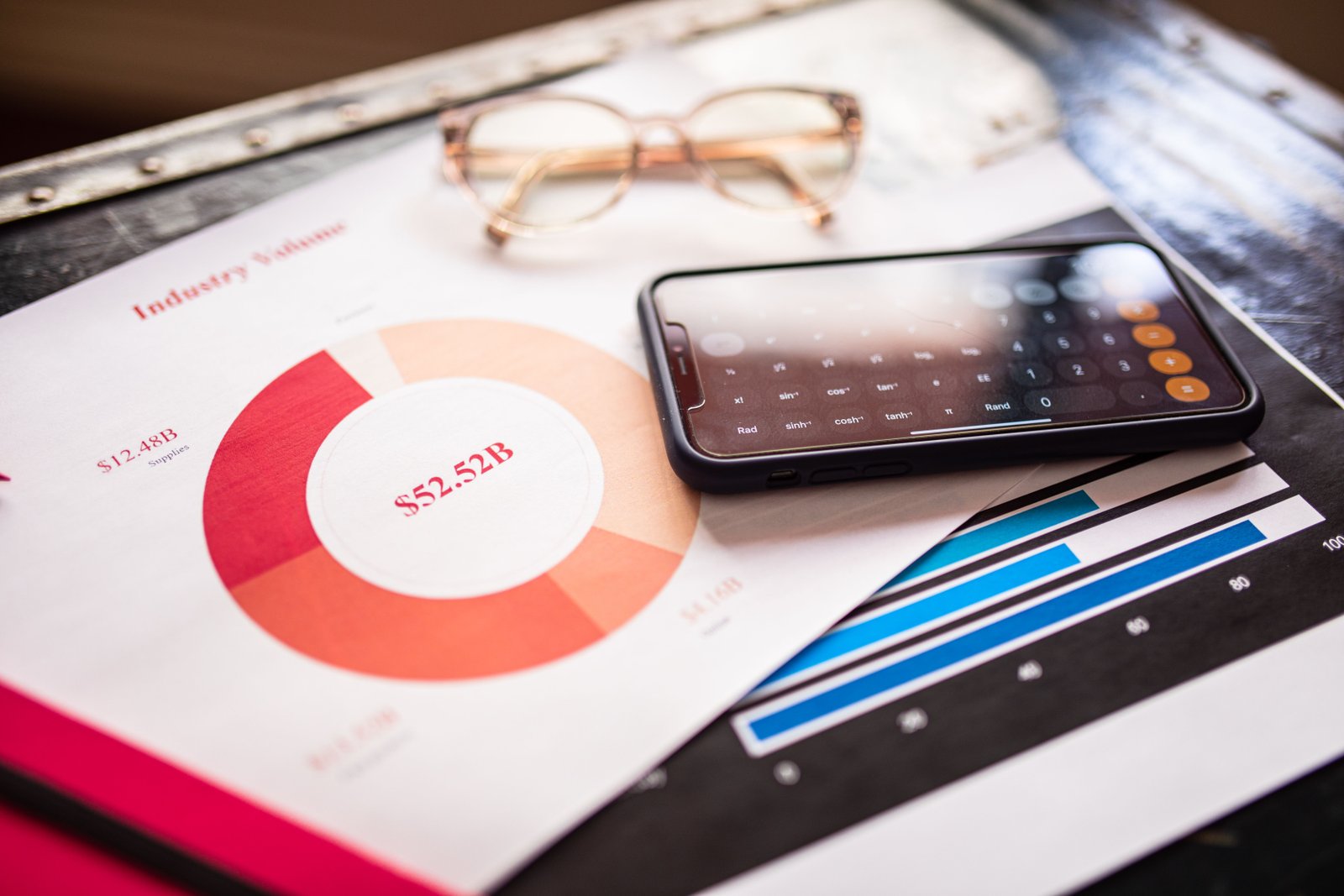 Smartphone resting on documents with marketing charts
