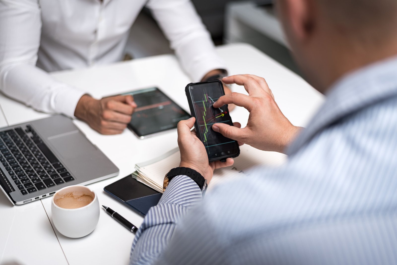 Professionals analyzing social and trading charts on phones and tablets